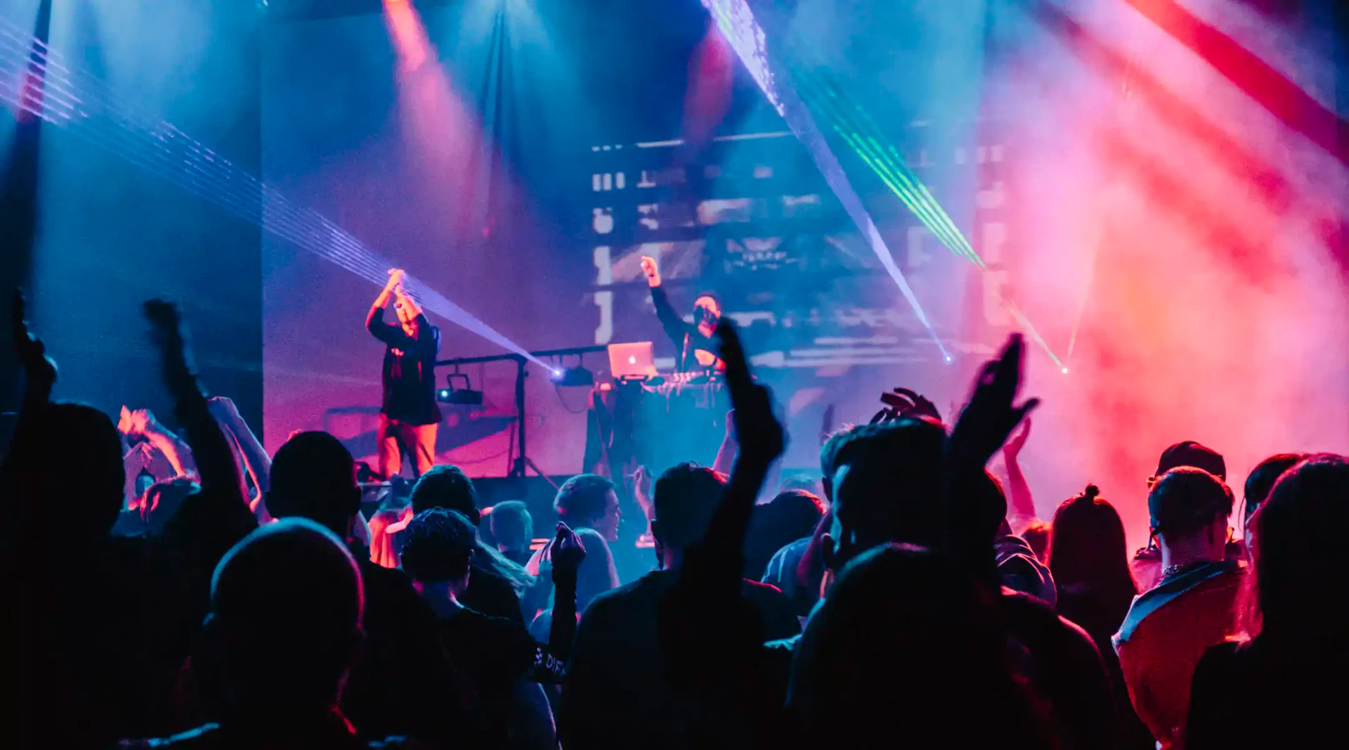 Concert électro, DJ et foule sous les lasers bleu et rouge